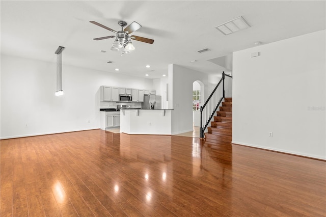 unfurnished living room featuring ceiling fan and hardwood / wood-style floors