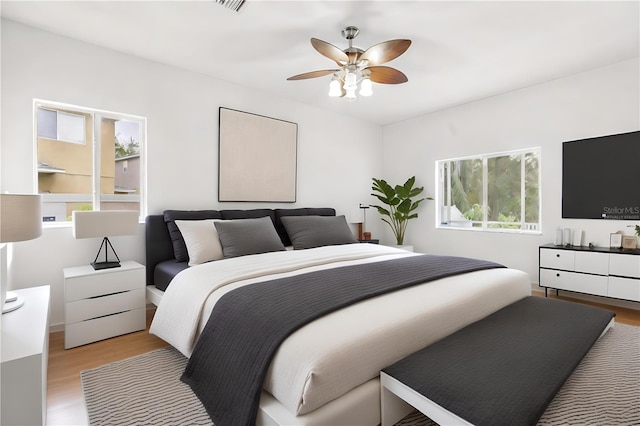 bedroom with ceiling fan and light hardwood / wood-style flooring