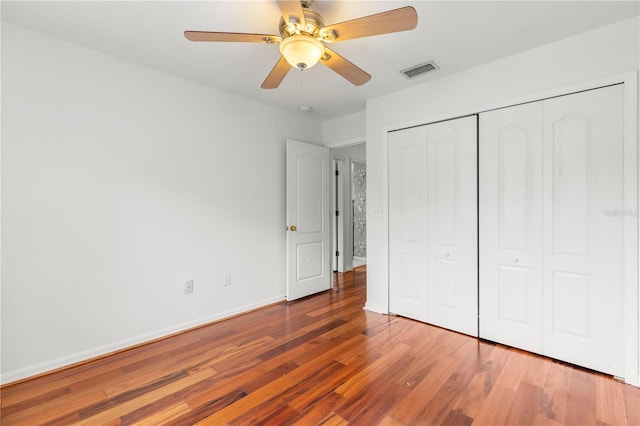 unfurnished bedroom featuring ceiling fan, hardwood / wood-style floors, and a closet