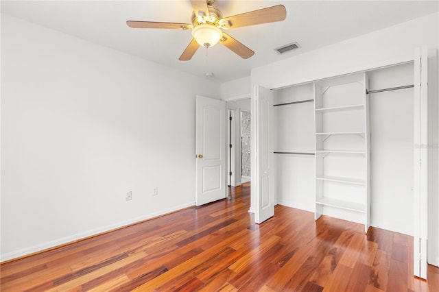 unfurnished bedroom with ceiling fan, a closet, and wood-type flooring