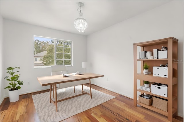 office area with wood-type flooring and a chandelier