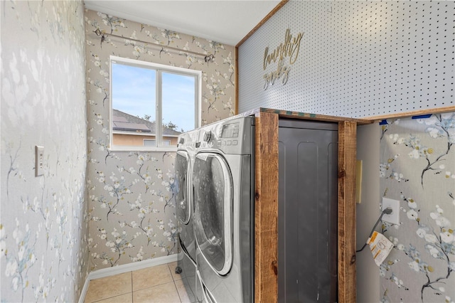 clothes washing area with light tile patterned floors and washer and clothes dryer