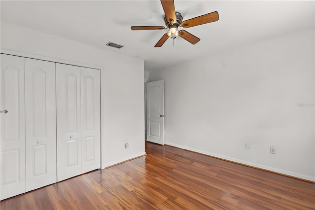 unfurnished bedroom with ceiling fan, a closet, and hardwood / wood-style flooring