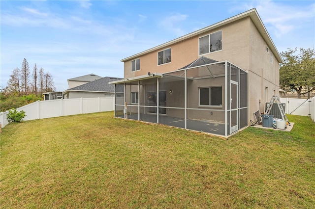 back of house with a lanai and a yard