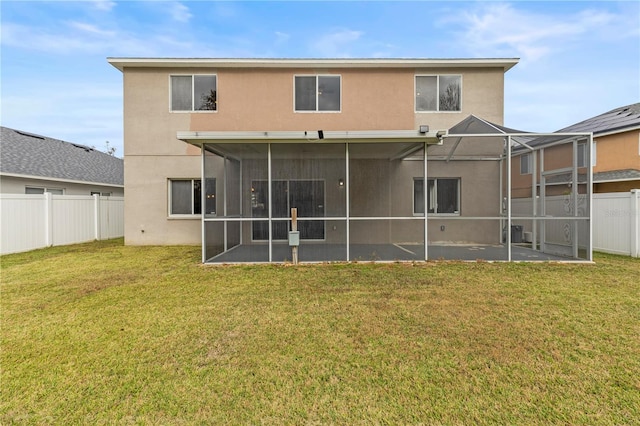 back of house featuring a lawn, a patio, and a lanai