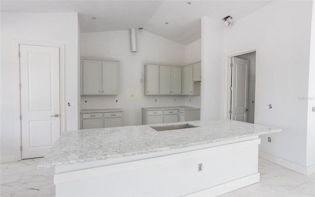 kitchen with vaulted ceiling, gray cabinetry, and a kitchen island