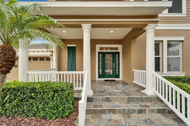 view of exterior entry with covered porch and stucco siding