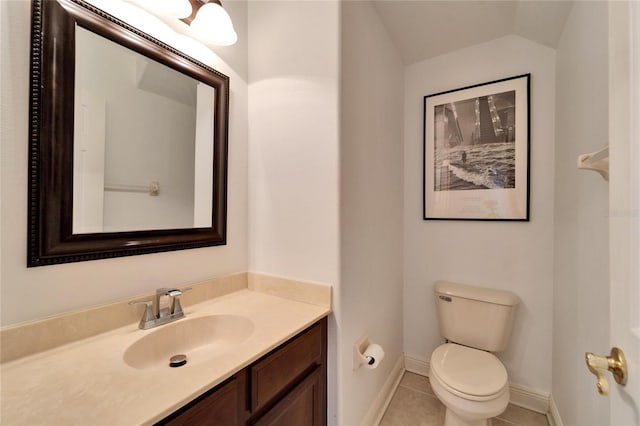 bathroom featuring tile patterned floors, vanity, toilet, and vaulted ceiling