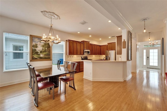 dining space with a chandelier and light wood-type flooring