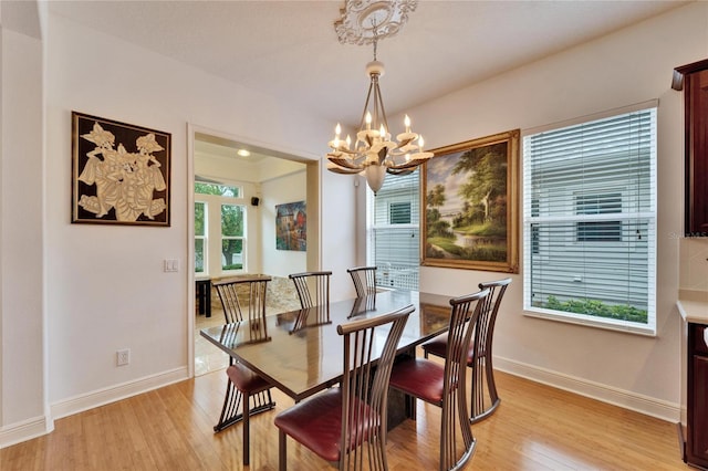 dining area featuring an inviting chandelier, plenty of natural light, and light wood-type flooring