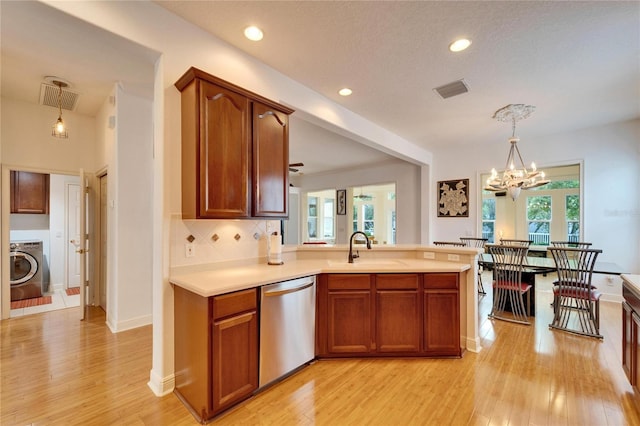 kitchen with hanging light fixtures, washer / dryer, sink, and dishwasher