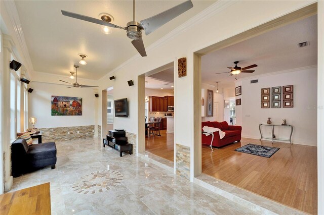 living room with ornamental molding and ceiling fan