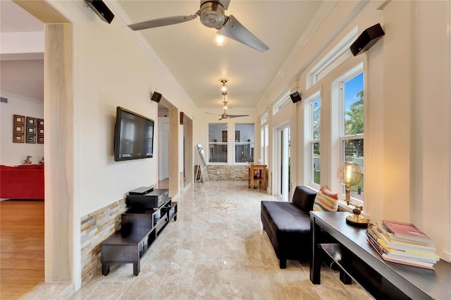 living area with ceiling fan and ornamental molding