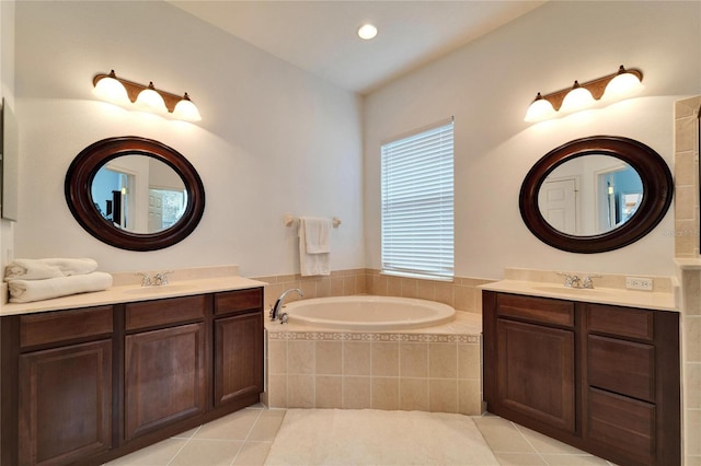 bathroom featuring tile patterned flooring, tiled tub, and vanity