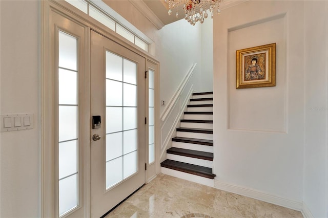 entryway featuring a notable chandelier and ornamental molding