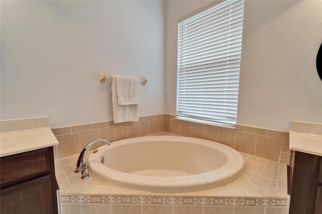 bathroom featuring vanity and a relaxing tiled tub