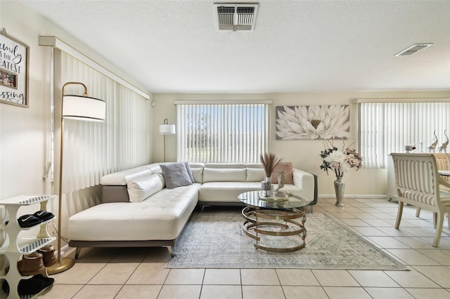 living room featuring a textured ceiling and light tile patterned floors