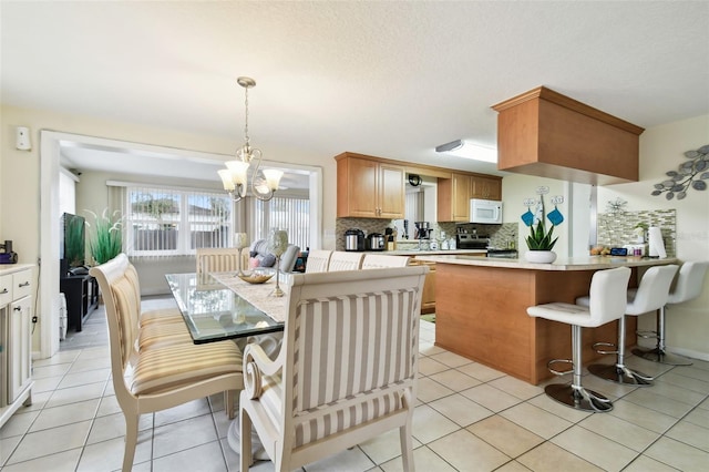 dining area featuring light tile patterned flooring and an inviting chandelier