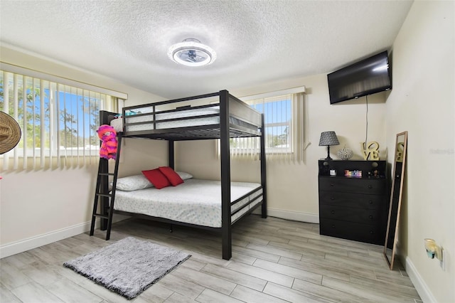 bedroom featuring a textured ceiling and light wood-type flooring