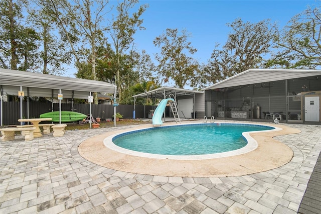 view of swimming pool featuring a water slide and a patio area