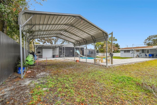 view of yard with a carport and a fenced in pool