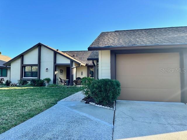 ranch-style home with a garage and a front lawn