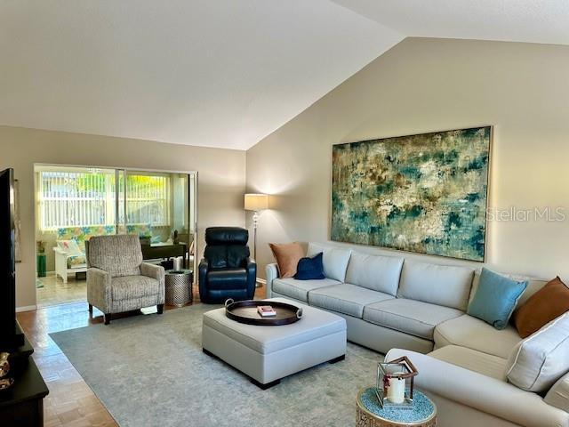 living room with lofted ceiling and parquet flooring