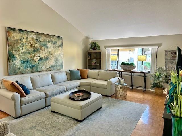 living room featuring parquet flooring and high vaulted ceiling