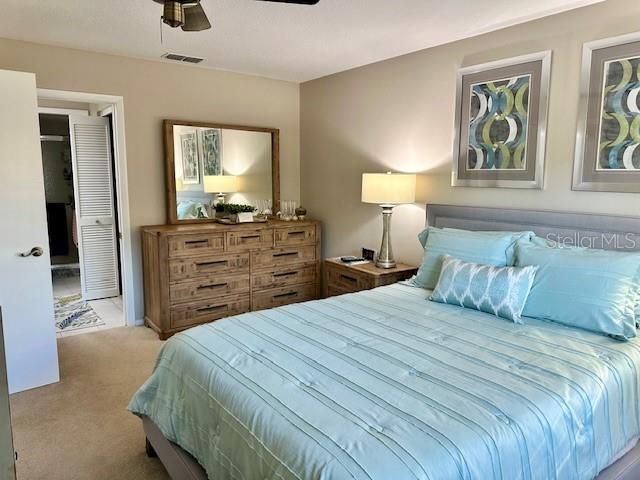 bedroom with light carpet and ceiling fan