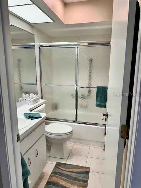 full bathroom featuring vanity, tile patterned flooring, enclosed tub / shower combo, and toilet