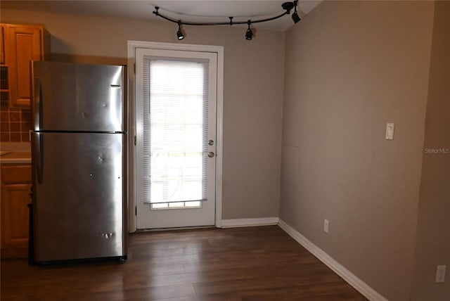 interior space featuring backsplash, dark hardwood / wood-style floors, and stainless steel fridge