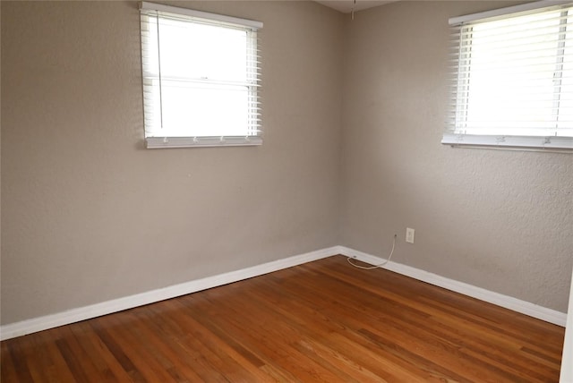 unfurnished room with hardwood / wood-style flooring