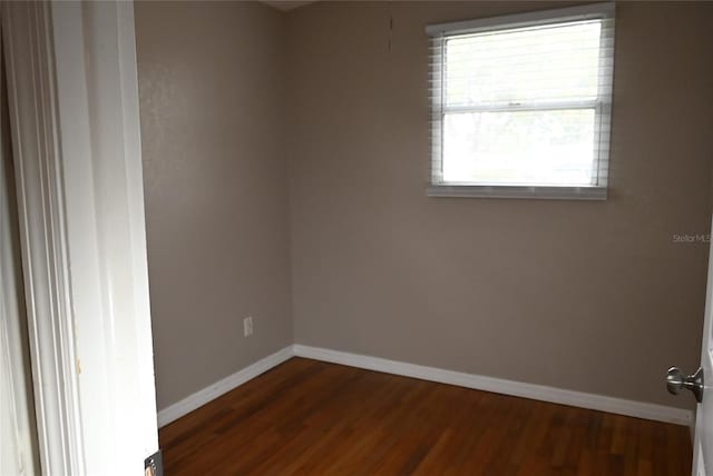 empty room with dark hardwood / wood-style flooring