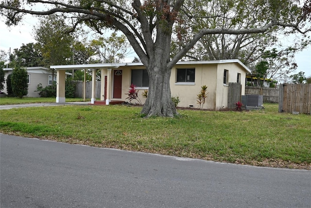 ranch-style home featuring central AC unit and a front lawn