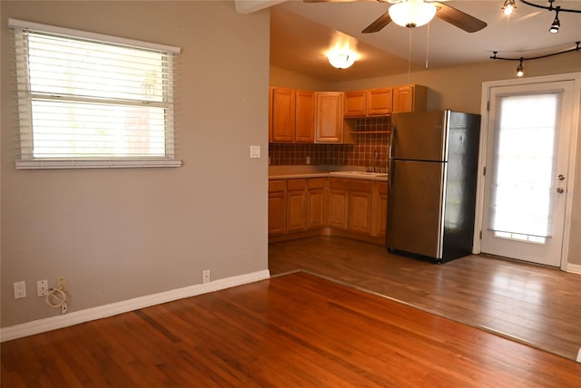 kitchen featuring hardwood / wood-style floors, decorative backsplash, stainless steel fridge, and a wealth of natural light