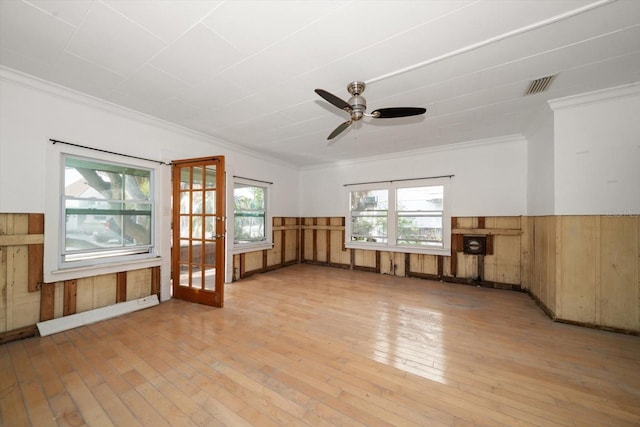 unfurnished room with crown molding, plenty of natural light, and light hardwood / wood-style floors