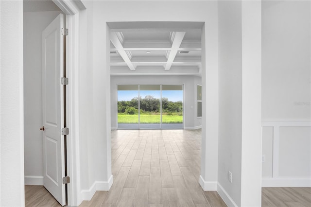 hall with beamed ceiling, coffered ceiling, and light wood-type flooring