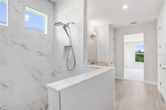 bathroom featuring sink and a tile shower