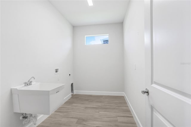 clothes washing area featuring sink, hookup for a washing machine, light hardwood / wood-style flooring, and electric dryer hookup