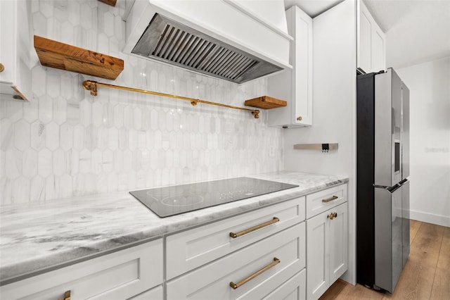 kitchen with premium range hood, black electric stovetop, light hardwood / wood-style floors, white cabinets, and stainless steel fridge with ice dispenser