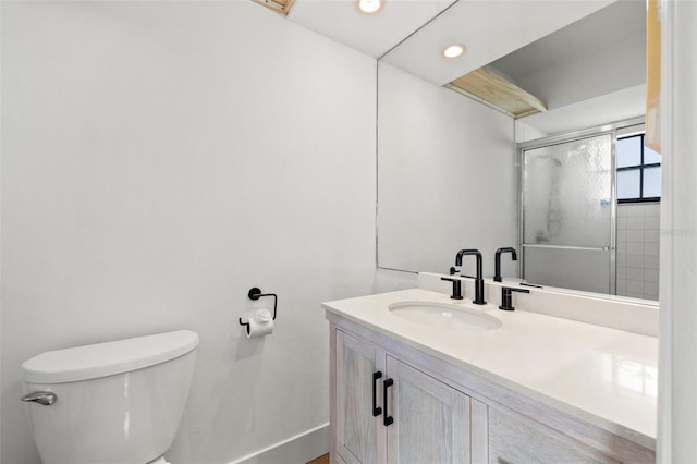 bathroom with vanity, an enclosed shower, and toilet