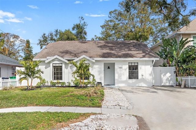 view of front facade featuring fence, a front lawn, and stucco siding