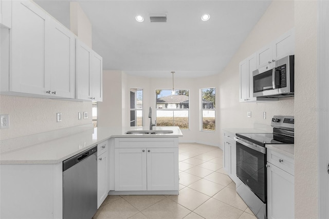 kitchen featuring pendant lighting, appliances with stainless steel finishes, white cabinetry, sink, and kitchen peninsula