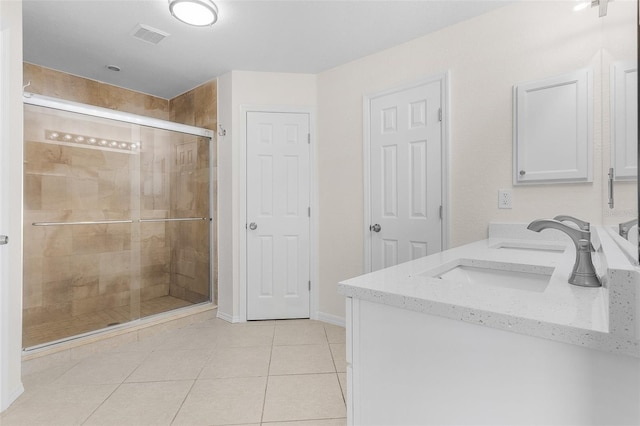 bathroom featuring tile patterned flooring, an enclosed shower, and vanity