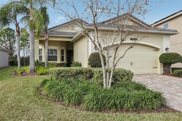 single story home featuring a garage and a front lawn