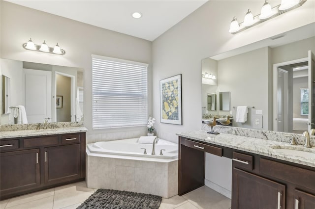 bathroom featuring a relaxing tiled tub, tile patterned floors, vanity, and a wealth of natural light