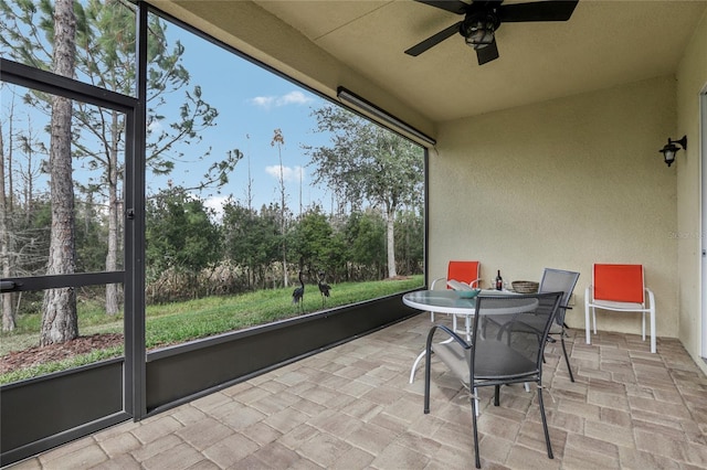 sunroom / solarium featuring plenty of natural light and ceiling fan