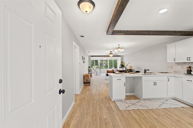 kitchen featuring white cabinets, backsplash, sink, and light hardwood / wood-style floors