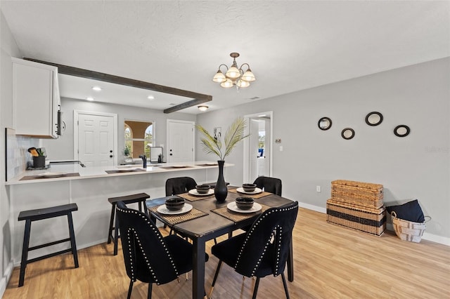 dining space featuring a notable chandelier and light hardwood / wood-style floors