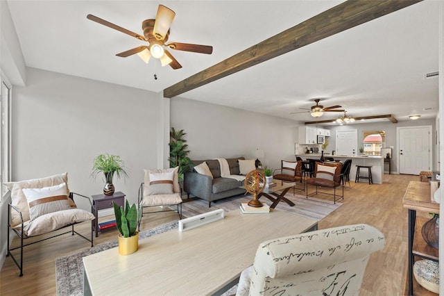 living room with beam ceiling and light hardwood / wood-style flooring